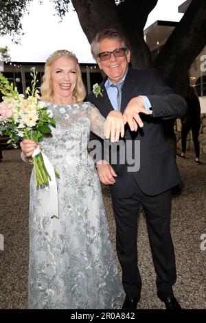 May 6, 2023, Ojai, California, USA: EXCLUSIVE! Newlyweds Former Happy Days star 'Potsie' aka ANSON WILLIAMS, 73, and SHARON MAHARRY, 64 show off rings. The actor, who filed for divorce from his wife of 30 years in 2019, wore a black suit with a light blue shirt and a gray patterned tie. He had a boutonniere on the lapel of his jacket and wore black eyeglasses. The bride, who is a real estate agent in Ojai, California, wore a gorgeous, long-sleeved floor length white lace gown with a boat neck and full skirt. She wore her blonde hair pinned back off her face and carried a pretty bouquet of rose Stock Photo