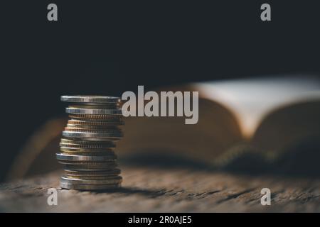 One tenth or tithe is basis on which Bible teaches us to give one tenth of first fruit to God. coins with Holy Bible. Biblical concept of Christian of Stock Photo