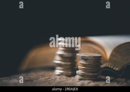 One tenth or tithe is basis on which Bible teaches us to give one tenth of first fruit to God. coins with Holy Bible. Biblical concept of Christian of Stock Photo