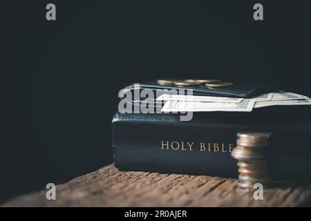 One tenth or tithe is basis on which Bible teaches us to give one tenth of first fruit to God. coins with Holy Bible. Biblical concept of Christian of Stock Photo