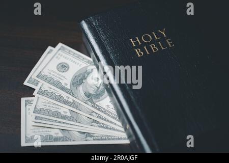 One tenth or tithe is basis on which Bible teaches us to give one tenth of first fruit to God. coins with Holy Bible. Biblical concept of Christian of Stock Photo