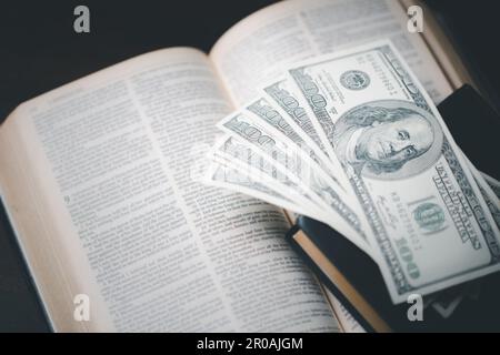 One tenth or tithe is basis on which Bible teaches us to give one tenth of first fruit to God. coins with Holy Bible. Biblical concept of Christian of Stock Photo