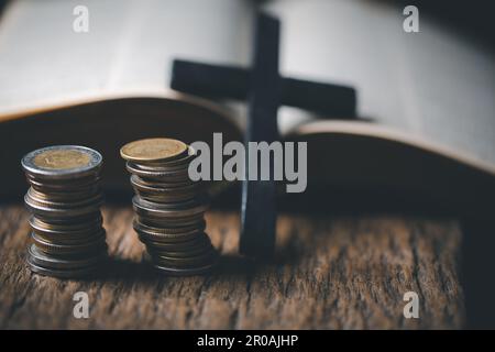 One tenth or tithe is basis on which Bible teaches us to give one tenth of first fruit to God. coins with Holy Bible. Biblical concept of Christian of Stock Photo