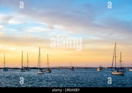 View from the St. Augustine, Florida, waterfront of sailboats on Matanzas Bay at sunset with Vilano Beach in the background. (USA) Stock Photo