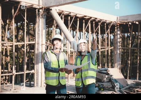 Two specialists inspect commercial, Industrial building construction site. Real estate project with civil engineer, designing commercial buildings on Stock Photo