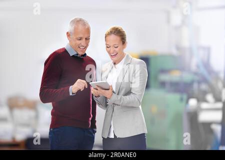 Pleased with the numbers. two factory managers using a digital tablet during an inspection. Stock Photo
