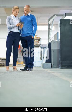 Ensuring productivity is at its highest. Two professional factory managers using a tablet to monitor productivity. Stock Photo