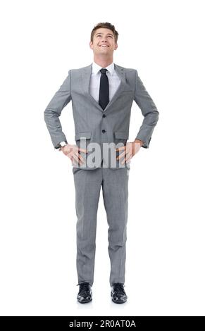 Ready to climb the corporate ladder. A young businessman standing with his hands on his hips looking upwards. Stock Photo