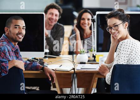 Make creativity a job. Portrait of a group of young office workers sitting at their computers. Stock Photo