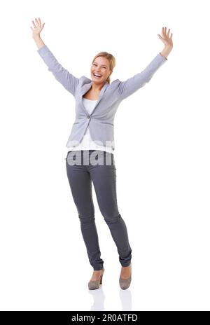 Caucasian woman with arms raised celebrating her success in a field on ...