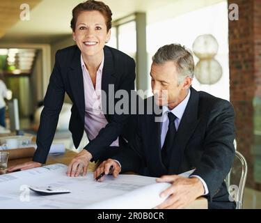 Theyre a great team of planners. A professional businessman going over some plans carefully with a coworker. Stock Photo