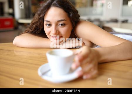 Woman in a coffee shop catching cup on a table Stock Photo