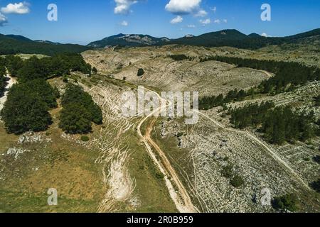 Aerial view. Rugged karst plateaus and fresh beech woods along the cart track that leads to the sanctuary of the Holy Trinity of Vallepietra Stock Photo