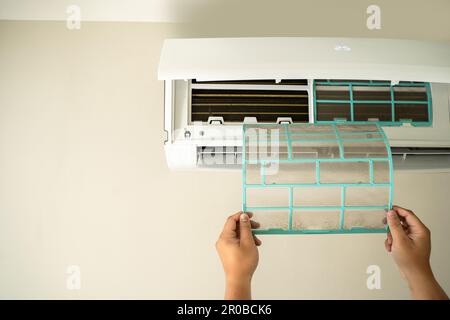 Male professional technician fixing An electrician repairs an air conditioner indoors. removing air filter repairing hot temperatures Stock Photo