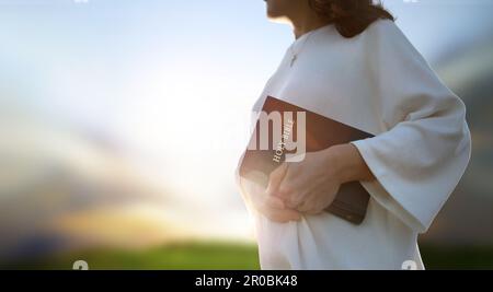 Christian background and worship and evangelism concept with church hand holding holy bible and preaching the gospel of jesus christ Stock Photo