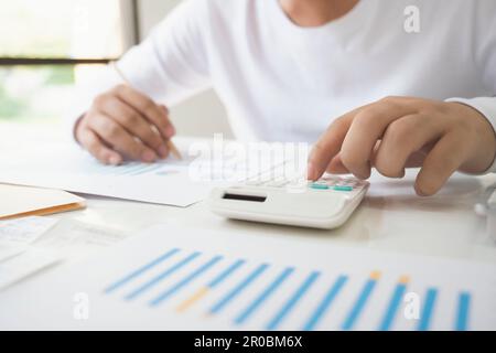 business man Using calculator analyzing investment chart on the Stock Photo