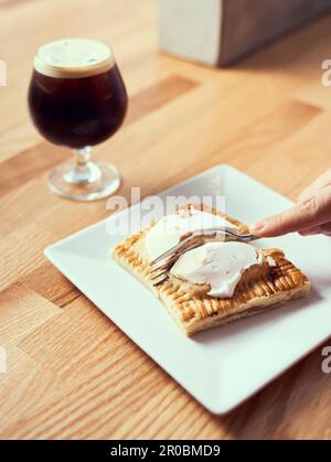 A pop tart pastry being cut and served with nitro cold brew. Stock Photo