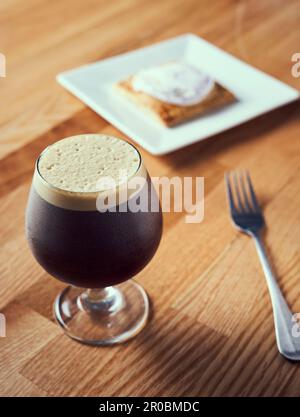 A nitro cold brew served with breakfast pastry. Stock Photo