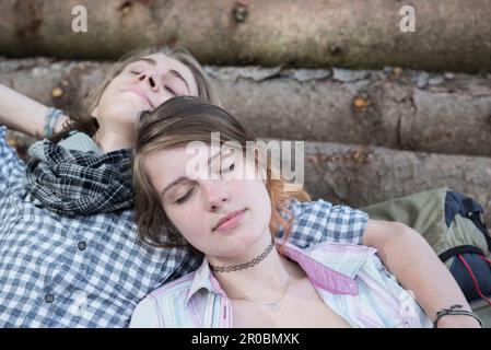 Close-up of young couple sleeping on woodpile, Bavaria, Germany Stock Photo