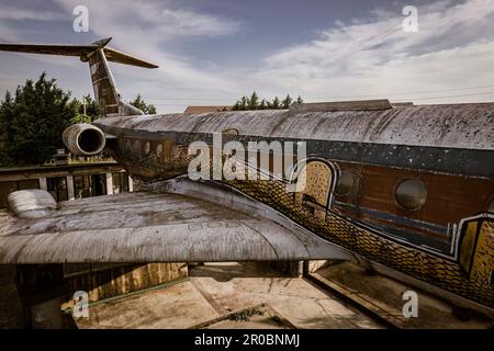A close-up shot of an abandoned airplane covered in graffiti, showcasing urban decay and artistic expression. Stock Photo