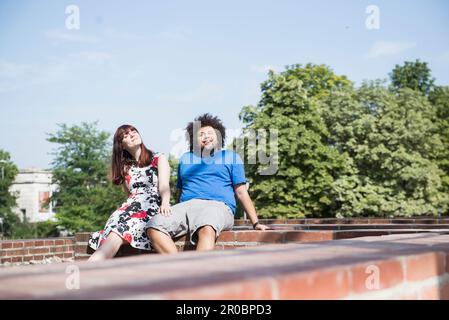 Relaxed young couple sitting outdoors Stock Photo