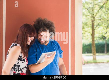 Happy young couple using digital tablet and headphones Stock Photo
