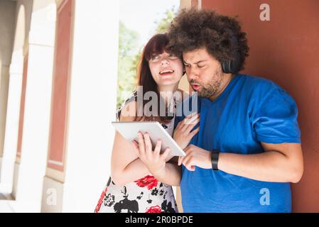 Young couple using digital tablet and headphones Stock Photo