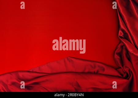 A blood red satin fabric on a smooth red surface Stock Photo