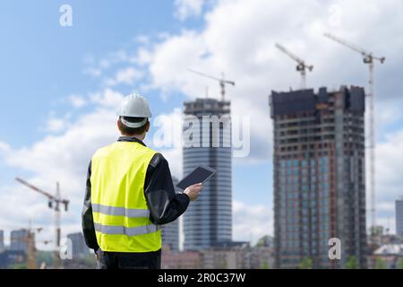 Engineer with a digital tablet on the background of a building under construction. High quality photo Stock Photo