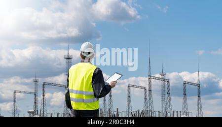 Worker with digital tablet on a background of power station. High quality photo Stock Photo