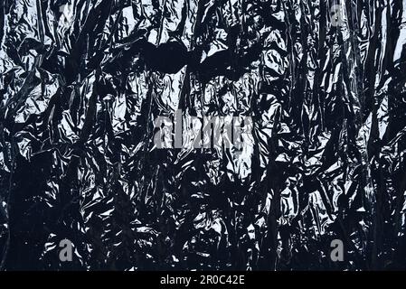 Cover plastic polyethylene packaging on black background. Transparent plastic stretch film texture. Transparent plastic wrap Stock Photo