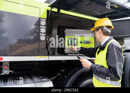 Worker with digital tablet operating construction machine equipment. High quality photo Stock Photo