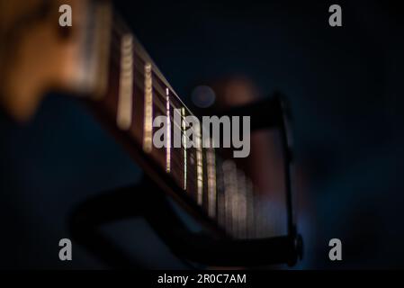 Close Up of electric guitar neck to bottom in guitar stand Stock Photo