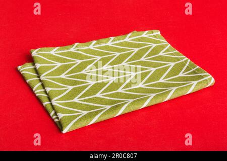 top view with green kitchen napkin isolated on table background. Folded cloth for mockup with copy space, Flat lay. Minimal style. Stock Photo