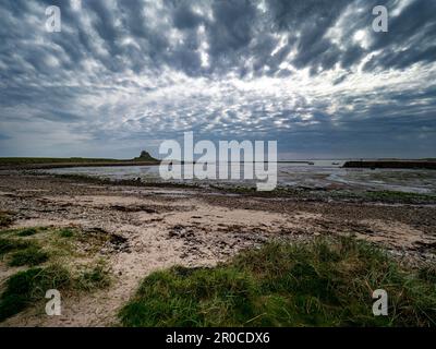 Spectacular clouds over Lindisfarne Castle, viewed from Holy Island Beach, near Berwick-upon-Tweed,  off the Northumberland coast Stock Photo