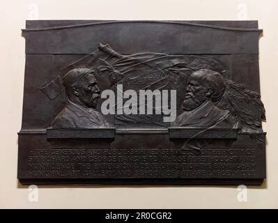 Memorial Tablet of Sir Richard and George Tangye, 1908. Situated on the stairwell in the entrance to the Birmingham Museum and Art Gallery, Chamberlain Square.. Richard and George Tangye were engineering manufacturers, patrons of the arts and contributed a large sum to the building of the Museum & Art Gallery, and the Birmingham School of Art on Margaret Street.. Sculptor: William Robert Colton. Bronze and Marble Stock Photo