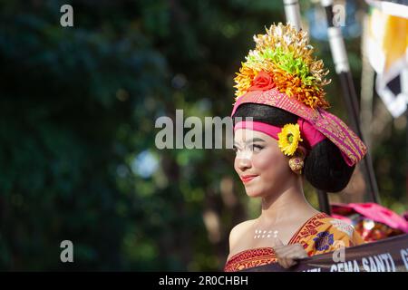 Denpasar, Bali island, Indonesia - June 11, 2016: Procession of beautiful Balinese women in traditional costumes - sarong, carry offering Stock Photo