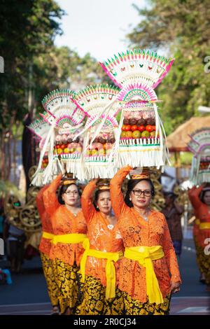 Denpasar, Bali island, Indonesia - June 11, 2016: Procession of beautiful Balinese women in traditional costumes - sarong, carry offering on heads Stock Photo