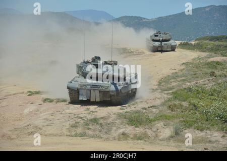 Capo Teulada, Italy. 05 May, 2023. German Army Leopard 2A7V main battle tanks with the Panzerbataillon 393 armor battalion conduct tactical maneuvers during NATO Exercise Nobel Jump 2023 at the Capo Teulada Training Area, May 5, 2023 in Capo Teulada, Sardinia, Italy.  Credit: MSgt Carl Schulze/NATO Command Naples/Alamy Live News Stock Photo
