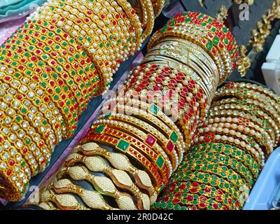 Golden Bangles display in Shop for women, Metal Bangles Arranged On The Shelf For Sell, Series of bangles. Selective Focus. Stock Photo