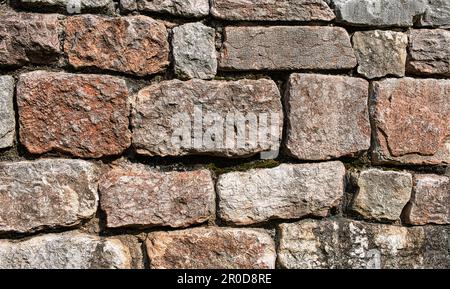 Wall with large squared stones of pink granite from the Italian Alps, a balanced texture and an impression of solidity. Stock Photo