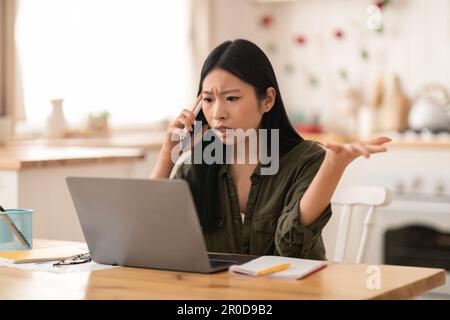 Angry asian businesswoman fighting with assistant on phone Stock Photo
