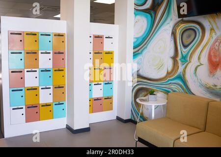 Bright and colourful wall of lockers in foyer of coworking space Stock Photo