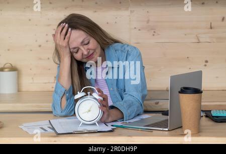 A thoughtful woman drinking a lot of coffee while doing creative work Stock Photo