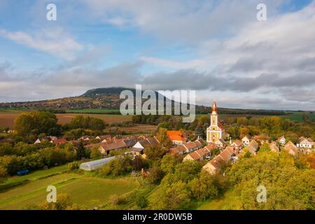 Aerial view about a tiny village called Borszorcsok, Hungary. Somlo hill in the background. Cloudy sky and beautiful colored trees. Stock Photo