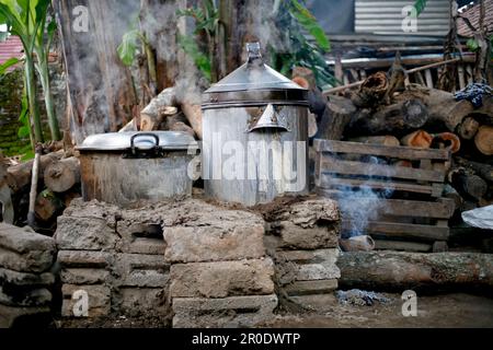 Rural kitchen. Traditional stoves used by residents in rural Indonesia, made of clay, fueled with wood, Cooking Food On Soil Stove With Dry Leafs And Stock Photo