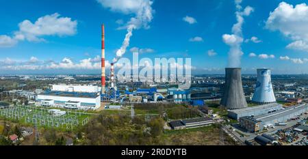 Coal combined heat and power plant (CHPP) in Krakow, Poland. High old chimney not in use anymore and a new smaller one with filters generating a white Stock Photo