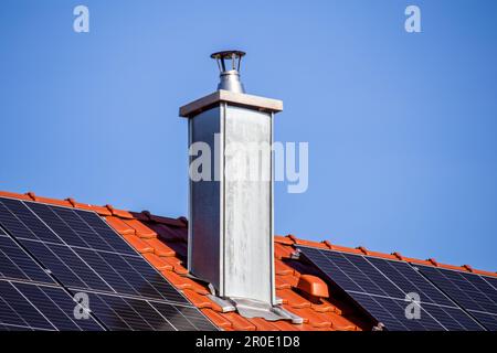 New stainless steel chimney on the roof of a residential house Stock Photo