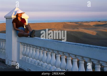 Woman enjoying the evening sun on the balustrade of Hotel Riu Palace, Playa del Ingles, Gran Canaria, Canary Islands, Spain Stock Photo