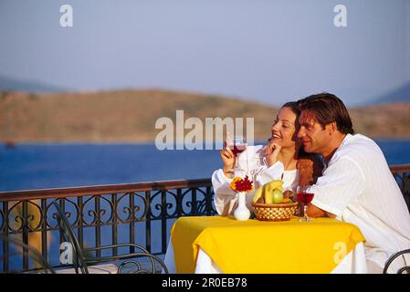 Enamored couple drinking wine on the terrace in a restaurant Stock Photo